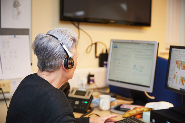 A photo showing a call handler using a computer