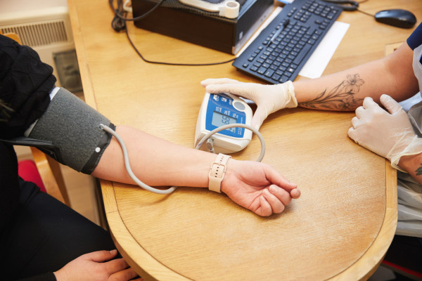A photo showing a nurse taking a patients blood pressure