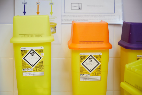 A photo showing three sharps bins