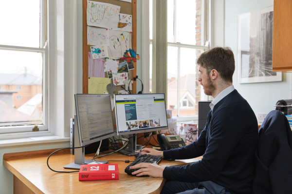 A photo showing a pharmacist using a computer