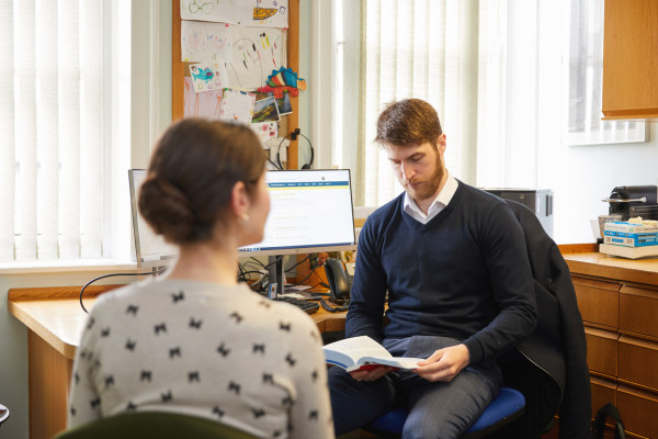 A photo showing a pharmacist speaking to a patient