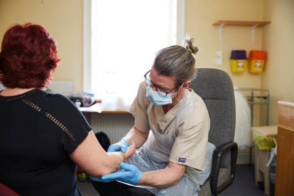A photo showing a musculoskeletal practitioner reviewing a patients arm